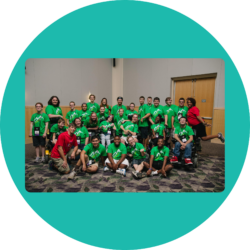 Group photo of the I'm Determined Youth leaders and Co-State Coordinators at the end of a Youth & Family Summit. They are all wearing that year's summit shirt, a green t-shirt with a white mountain scene on the front.
