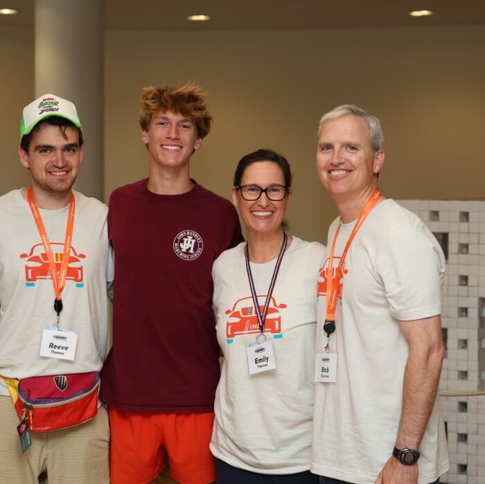 Photo of Reeve with his mom, dad, and brother at the IMD Youth and Family Summit smiling at the camera.