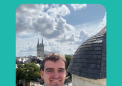 Image of Reeve taking a selfie in front of a tall building.